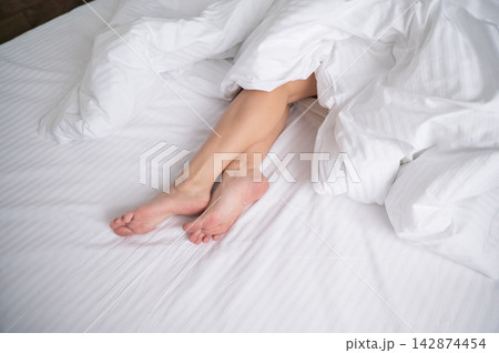 Foot fetish. Bare female feet protruding from under the blanket. Foot fetish. Bare female feet protruding from under the blanket. 142874454