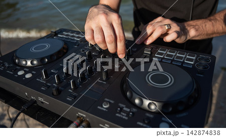 Close up of DJ's hands while working outdoors.  142874838