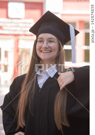 Young happy caucasian woman in graduation gown.  142874839