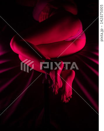 Women's legs in leather shackles. BDSM fetish. 142875005