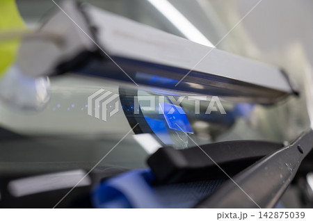 Windshield chip repair. A UV lamp dries the resin in the crack. Windshield chip repair. A UV lamp dries the resin in the crack. 142875039