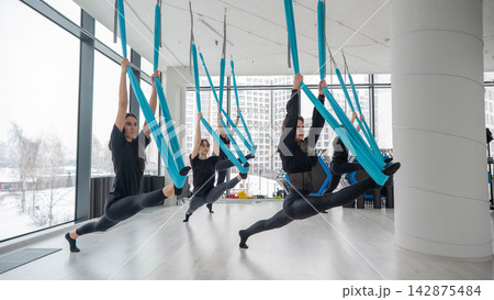 Group yoga class on hammocks. Group yoga class on hammocks. 142875484