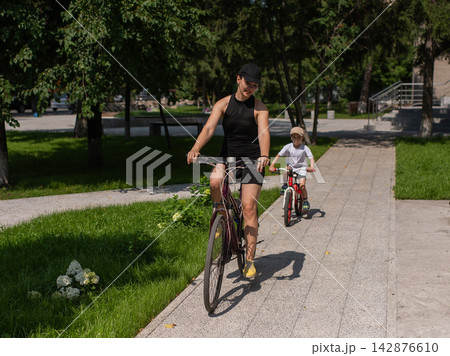 Mother and son riding a bicycle. Mother and son riding a bicycle. 142876610