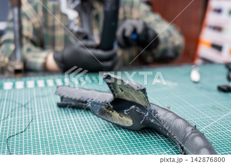 The mechanic changes the cover on the car steering wheel. The mechanic changes the cover on the car steering wheel. 142876800