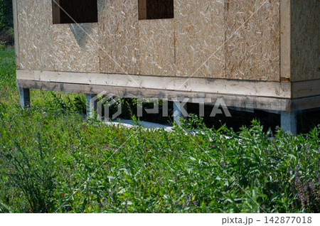 A close-up of concrete piles on a country house under construction. Cottage foundation. A close-up of concrete piles on a country house under construction. Cottage foundation. 142877018