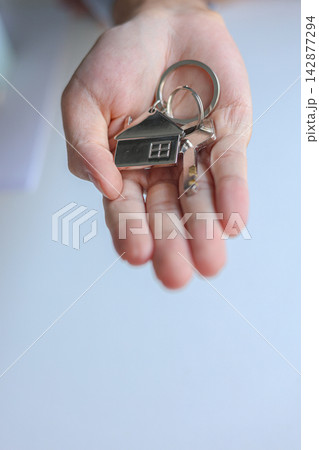 Hand giving house key. Concept for buying, selling, renting or leasing a new home. 142877294