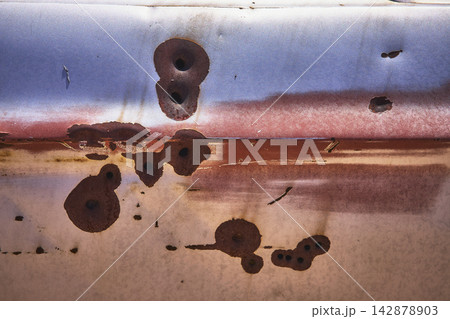 Rust Texture and Bullet Holes on Abandoned Vehicle Metal Surface 142878903