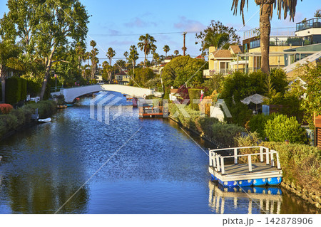 Venice Canal Bridge and Boats with Lush Homes and Palm Trees in Los Angeles Venice Canal Bridge and Boats with Lush Homes and Palm Trees in Los Angeles 142878906