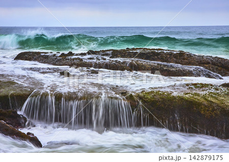 Ocean Waves Crashing on Rocky Ledge at Thousand Steps Beach California 142879175