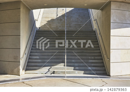 Modern Concrete Staircase with Sunlight and Architectural Symmetry Modern Concrete Staircase with Sunlight and Architectural Symmetry 142879363