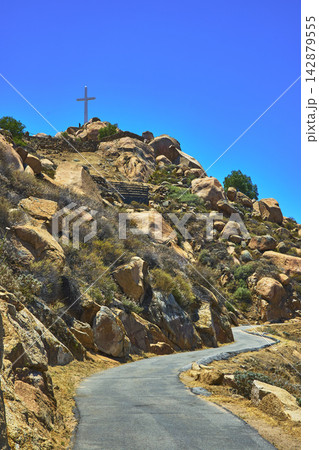 Mt Rubidoux Trail with Rocky Hillside and Cross under Clear Blue Sky in California Mt Rubidoux Trail with Rocky Hillside and Cross under Clear Blue Sky in California 142879555