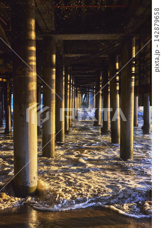 Santa Monica Pier Pillars with Ocean Waves and Golden Hour Reflections Beach California 142879658