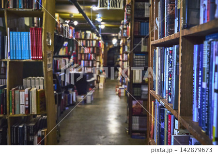 Bookstore Aisle with Tall Wooden Shelves and Colorful Books in Los Angeles Bookstore Aisle with Tall Wooden Shelves and Colorful Books in Los Angeles 142879673