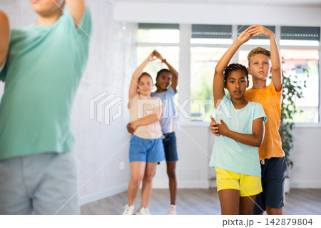 Multinational boys and girls enjoying active dance in studio Multinational boys and girls enjoying active dance in studio 142879804