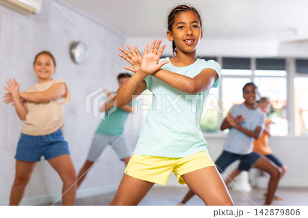 Dancing group of five children practicing new dance in modern studio 142879806