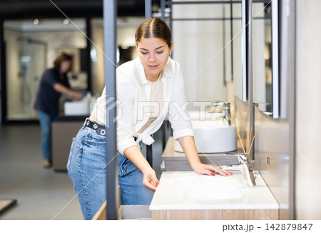 Confident woman picking out new bathroom sink in hardware store 142879847