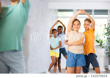 Preteen children learning to dance waltz in pairs in choreography class 142879929