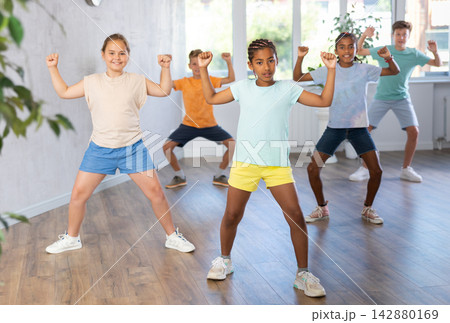 African girl perform choreographic exercises and teach energetic social dance hip hop with friends 142880169