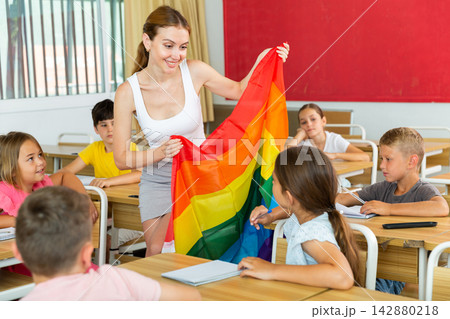 Positive female teacher standing with lgbt flag 142880218