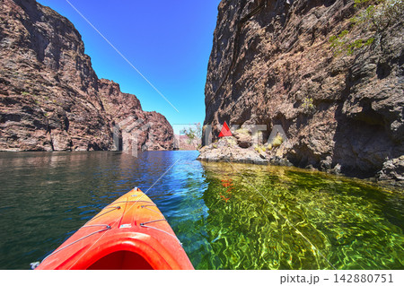 Kayak Adventure on Clear Colorado River Between Rocky Canyon Walls in Arizona Kayak Adventure on Clear Colorado River Between Rocky Canyon Walls in Arizona 142880751