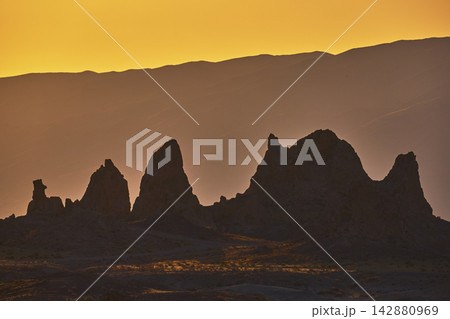 Trona Pinnacles Silhouette at Golden Hour with Sunlit California Desert Hills Trona Pinnacles Silhouette at Golden Hour with Sunlit California Desert Hills 142880969