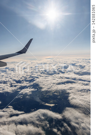 上空を飛ぶ飛行機から見た雲海 翼と青空の幻想的な風景 142881065