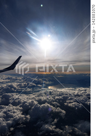 飛行機の翼と雲海 空から眺める雲と光の絶景 142881070