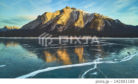 Frozen Lake and Snow Capped Mountain Reflections at Sunrise Winter Scenery 142881189