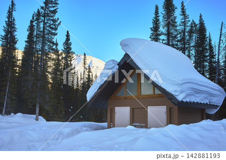 Snow Covered Cabin Winter Forest and Mountain in Banff Alberta Snow Covered Cabin Winter Forest and Mountain in Banff Alberta 142881193