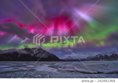 Northern Lights Over Frozen Lake and Snowy Mountains in Vibrant Winter Night Northern Lights Over Frozen Lake and Snowy Mountains in Vibrant Winter Night 142881369