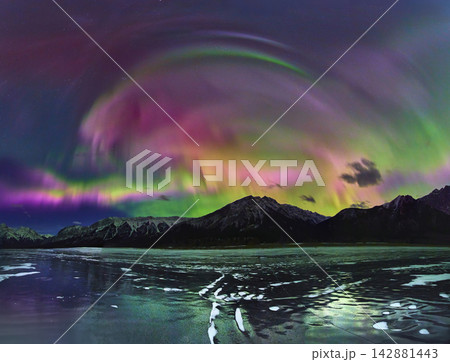 Panorama Northern Lights Over Frozen Lake and Snowy Mountains in Winter Night 142881443