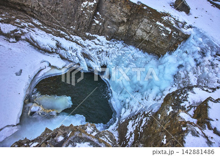 Top Down Frozen Waterfall Ice Pool and Rocky Canyon in Winter Top Down Frozen Waterfall Ice Pool and Rocky Canyon in Winter 142881486
