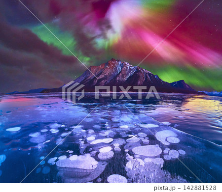Panorama Winter Northern Lights Over Frozen Lake with Ice Bubbles and Mountain Panorama Winter Northern Lights Over Frozen Lake with Ice Bubbles and Mountain 142881528