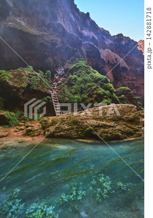 Havasupai Mooney Falls Trail Ladder and Chains Beside Turquoise Pool and Mossy Cliffs 142881718