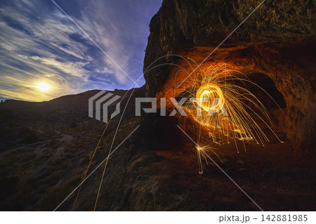 Peekaboo Canyon Cave with Steel Wool Sparks and Moonlit Desert Night Scene Peekaboo Canyon Cave with Steel Wool Sparks and Moonlit Desert Night Scene 142881985