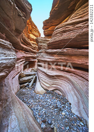 Colorful Eroded Sandstone Walls and Pebble Floor in Dramatic Slot Canyon Landscape Colorful Eroded Sandstone Walls and Pebble Floor in Dramatic Slot Canyon Landscape 142882211
