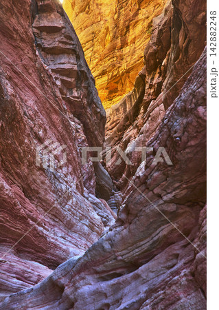 Colorful Sandstone Slot Canyon Walls with Sunlit Layers and Deep Shadows Colorful Sandstone Slot Canyon Walls with Sunlit Layers and Deep Shadows 142882248