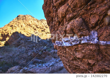 Close Up Red Rock Formation with White Gem Vein in Sunlit Desert Landscape Close Up Red Rock Formation with White Gem Vein in Sunlit Desert Landscape 142882270