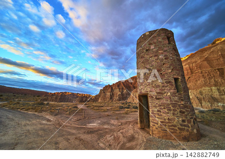 Abandoned CCC Water Tower at Sunset with Desert Cliffs and Dramatic Sky Abandoned CCC Water Tower at Sunset with Desert Cliffs and Dramatic Sky 142882749