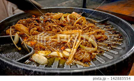 Sizzling Korean Grill Pan with Sliced Meat and Vegetables 142883554