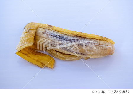 Rotten peeled banana with dark decaying flesh lying flat. Concept for spoiled fruit, organic waste, food degradation, and composting material. Rotten peeled banana with dark decaying flesh lying flat. Concept for spoiled fruit, organic waste, food degradation, and composting material. 142885627