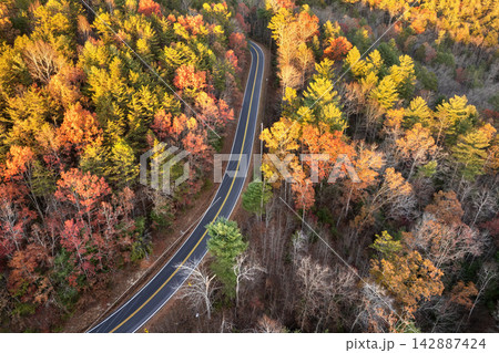 Road trip in fall season through Appalachian forest in Tennessee. Car driving on a winding road under colorful autumn canopy Road trip in fall season through Appalachian forest in Tennessee. Car driving on a winding road under colorful autumn canopy 142887424