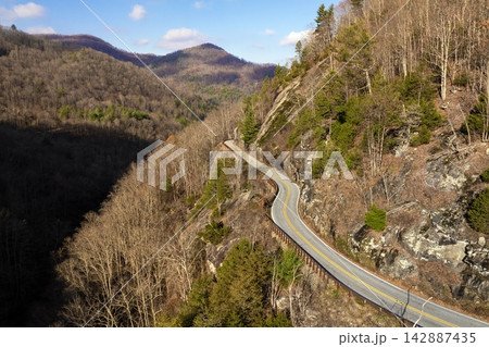 Highlands Road mountain highway in North Carolina during fall. Driving through forested hills and rocky ridgelines under colorful trees. Highlands Road mountain highway in North Carolina during fall. Driving through forested hills and rocky ridgelines under colorful trees. 142887435