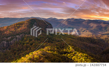 Autumn woods in Pisgah National Forest around Looking Glass Rock in North Carolina Appalachian mountains at colorful sundown. Bright yellow foliage on mountain slopes. Autumn woods in Pisgah National Forest around Looking Glass Rock in North Carolina Appalachian mountains at colorful sundown. Bright yellow foliage on mountain slopes. 142887734