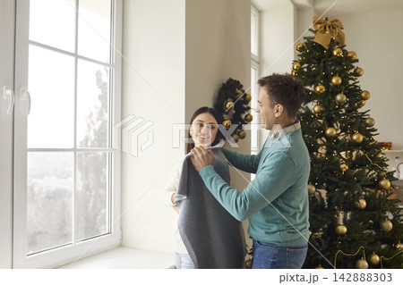 Loving happy couple enjoy leisure winter holidays, caring man covering woman with warm plaid  142888303