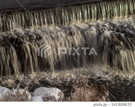 A small flat cascade in a calm river 142888633