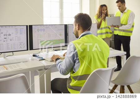 Engineers monitoring control room operations with analytics dashboards and safety Engineers monitoring control room operations with analytics dashboards and safety 142888869