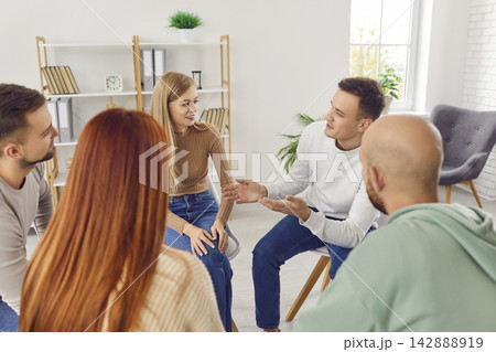 Group of business people sitting on chairs in office in a circle and talking on a meeting. 142888919