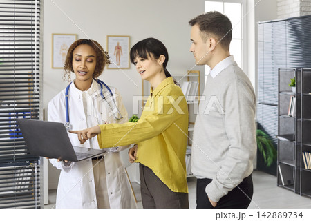 Couple reviewing results with doctor using laptop during fertility planning visit Couple reviewing results with doctor using laptop during fertility planning visit 142889734