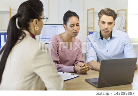 Couple meeting a financial advisor to discuss loan approval, mortgage planning Couple meeting a financial advisor to discuss loan approval, mortgage planning 142889887